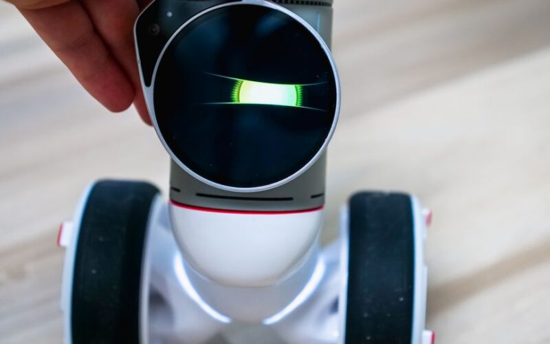 Detailed view of a wheeled robot being touched, showcasing tactile interaction.