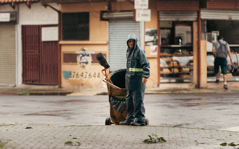 A street cleaner wearing rain gear works in Alajuela, Costa Rica during a rainy day.