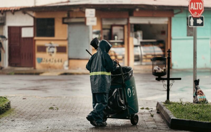 A street cleaner in a raincoat works on a wet street in Alajuela, Costa Rica.