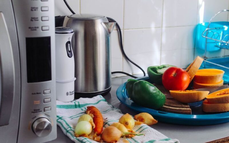 A modern home kitchen counter displaying fresh vegetables and appliances, ideal for healthy cooking.