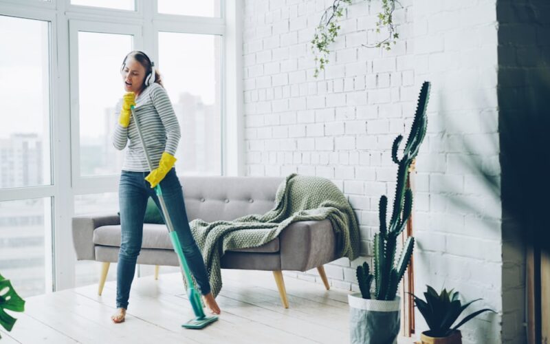 Woman with headphones cleaning and dancing
