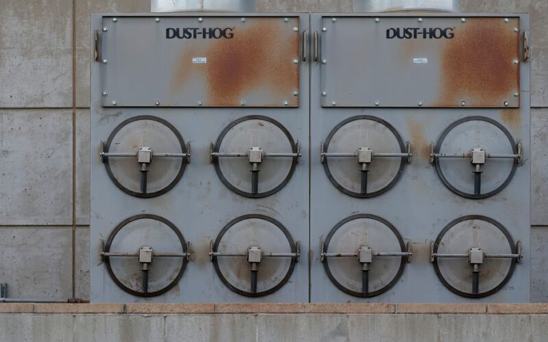 Close-up of a Dust-Hog industrial dust collector with six rusty filtration units.