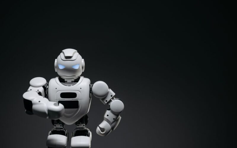 A sleek white robot showcasing modern robotics technology against a dark backdrop.