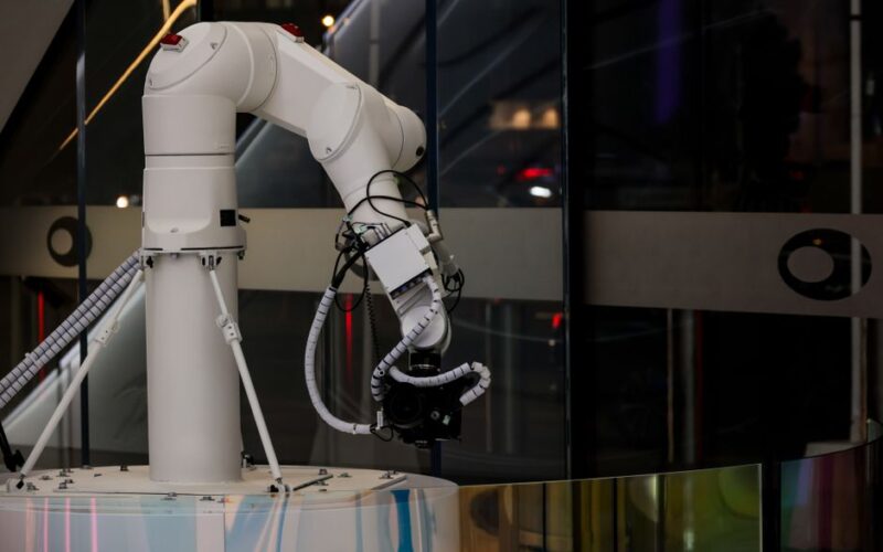 A white robotic arm operating indoors with a modern design and advanced technology.