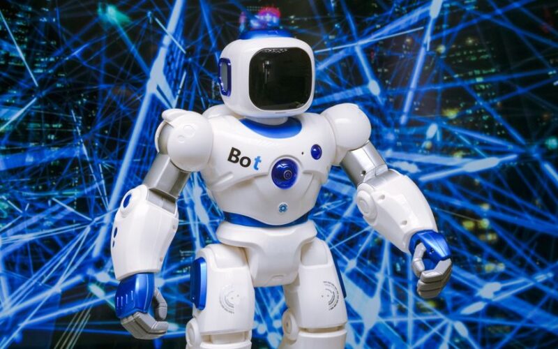 Advanced humanoid robot with glowing blue accents in a digital network setting.