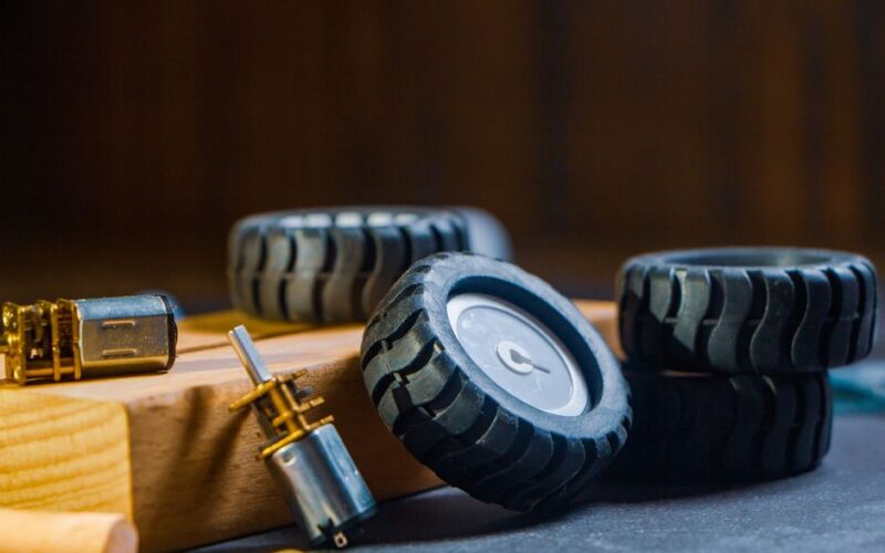 Detailed view of robotic wheels and motors on a workshop table, showcasing components for building robotics projects.