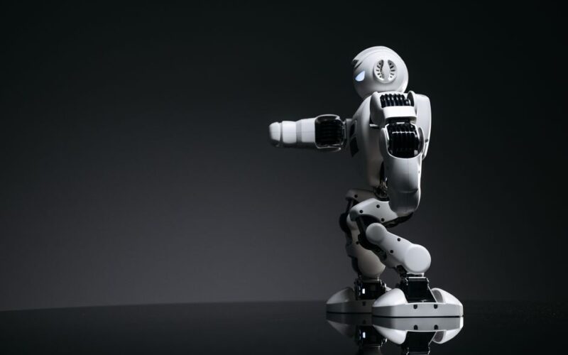 A white robot showcasing modern design on a sleek dark surface.