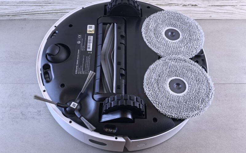 Detailed view of a robotic vacuum cleaner's underside showing brushes and wheels.