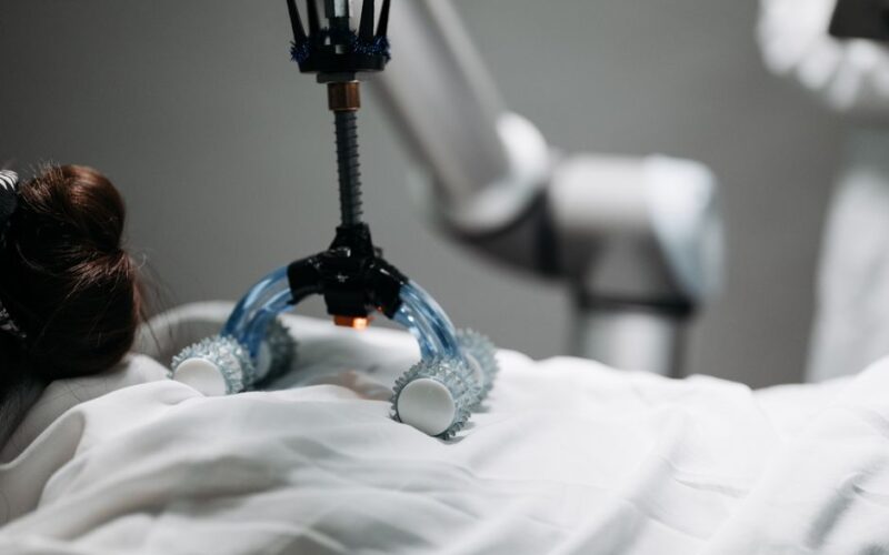 Close-up of a robotic massage arm applying therapy on a person, showcasing innovation.