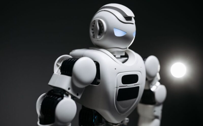 High-detail close-up image of a white robot with glowing eyes in studio lighting. Modern tech innovation.