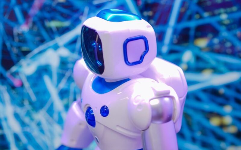 Close-up of a white and blue robot against a dynamic, futuristic tech backdrop.