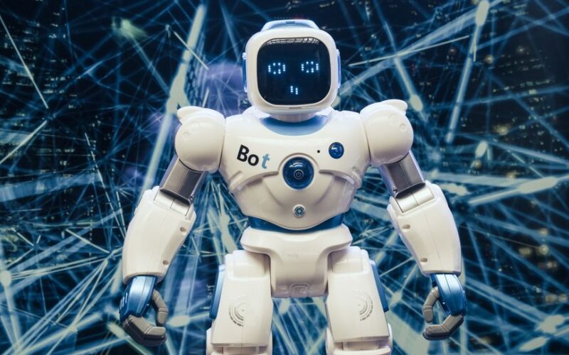 A modern humanoid robot with luminous features set against a digital network backdrop.