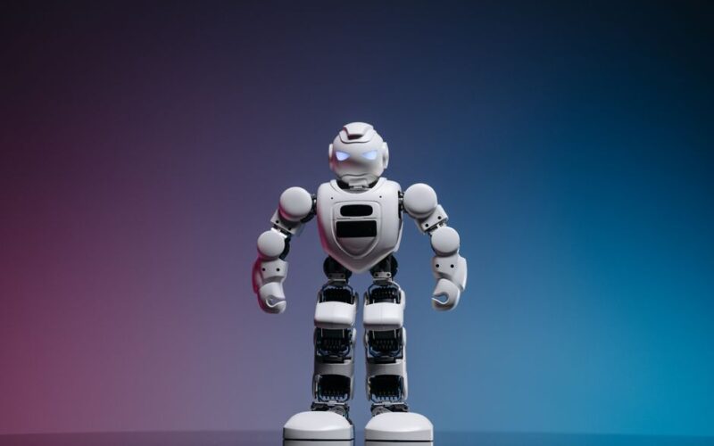 A modern toy robot standing on a gradient background, showcasing innovation and technology.