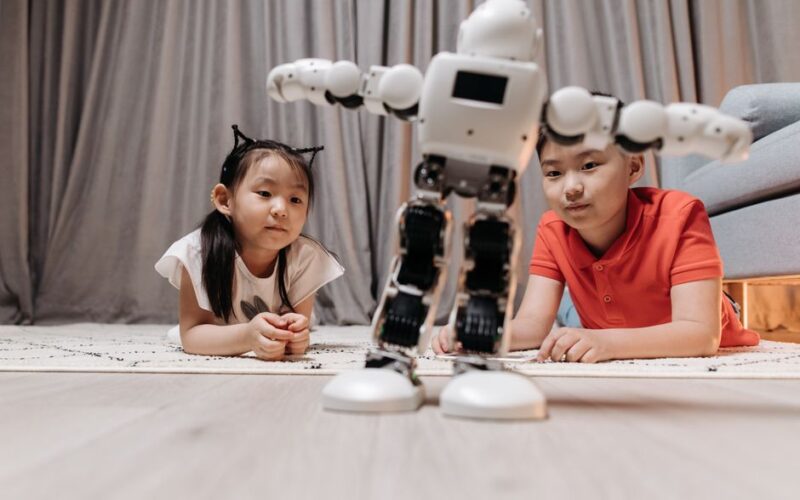 Children enjoying playtime with a modern android robot on a rug indoors.