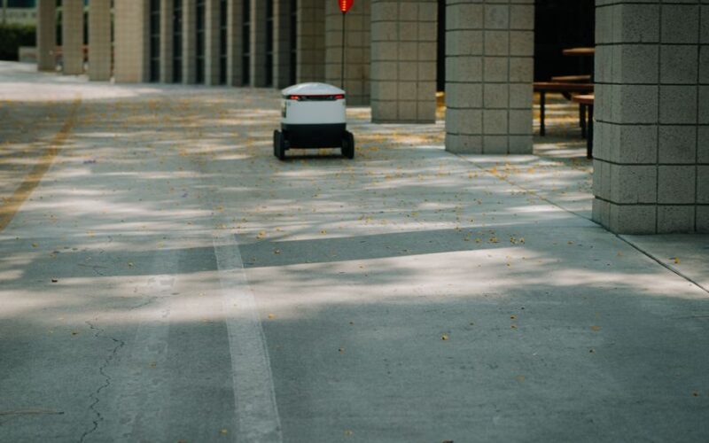 Futuristic autonomous robot on a delivery mission in a modern urban environment.