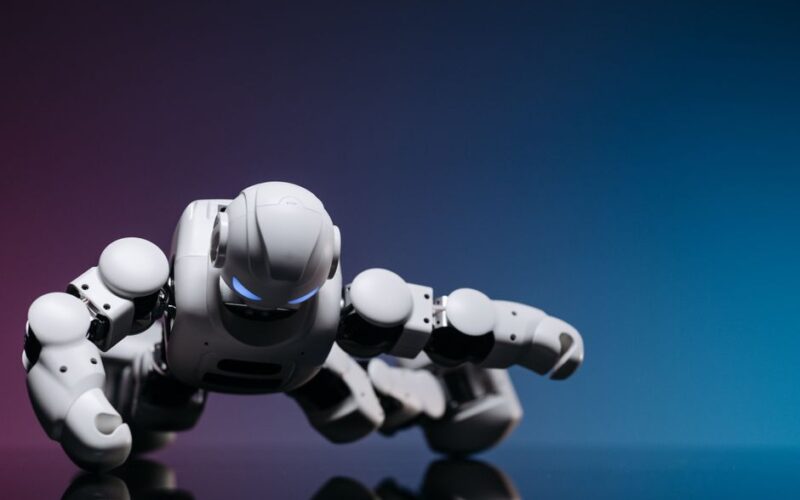 A close-up of a futuristic white robot performing a push-up on a glossy surface against a gradient backdrop.