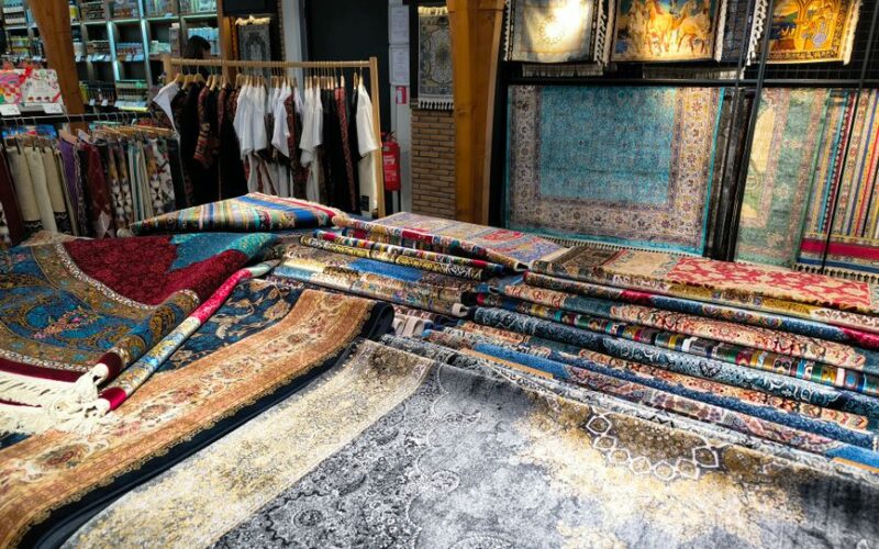 Colorful Turkish carpets on display in an Istanbul shop showcasing intricate designs and fabrics.