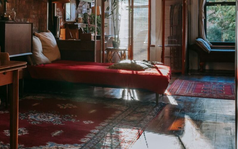 Interior of stylish bedroom with vintage wooden furniture decorated with antique carpets and green potted plants
