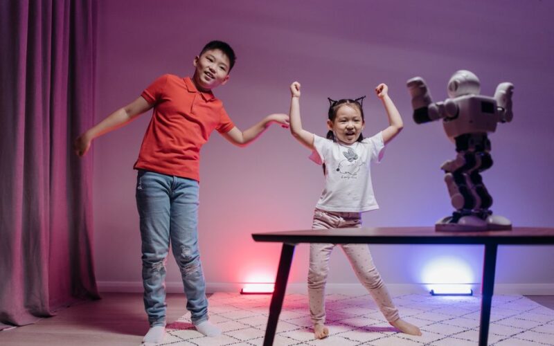 Two playful children engaging with a robot in a modern indoor environment.