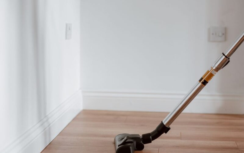Electrical apparatus collecting dust on wooden parquet in empty room of apartment in daylight