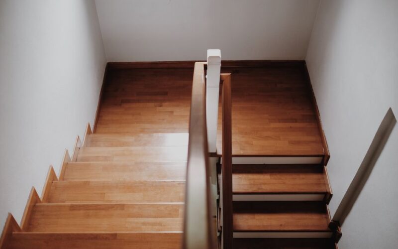Top view of a wooden staircase in a minimalist interior, showcasing clean lines and elegant design.