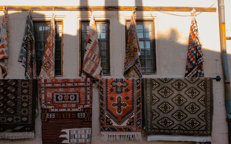 Assorted handmade carpets hanging on a wall in Nevşehir, Türkiye.