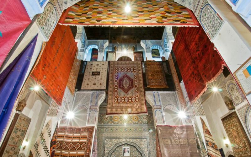 A captivating display of vibrant Moroccan rugs hanging in the historic Medina of Fès, Morocco.