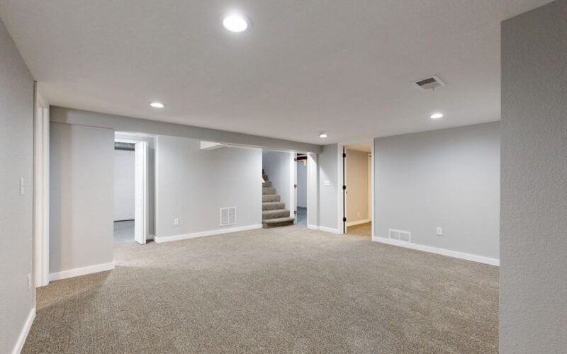 Spacious modern basement with neutral design and carpet flooring, perfect for renovation or real estate listings.