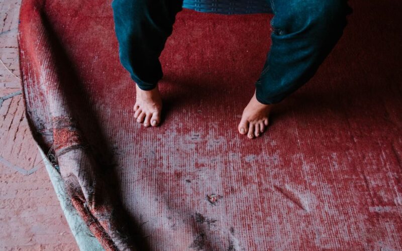 Bare feet on a worn vintage rug in Lahore, creating a rustic and cozy atmosphere.