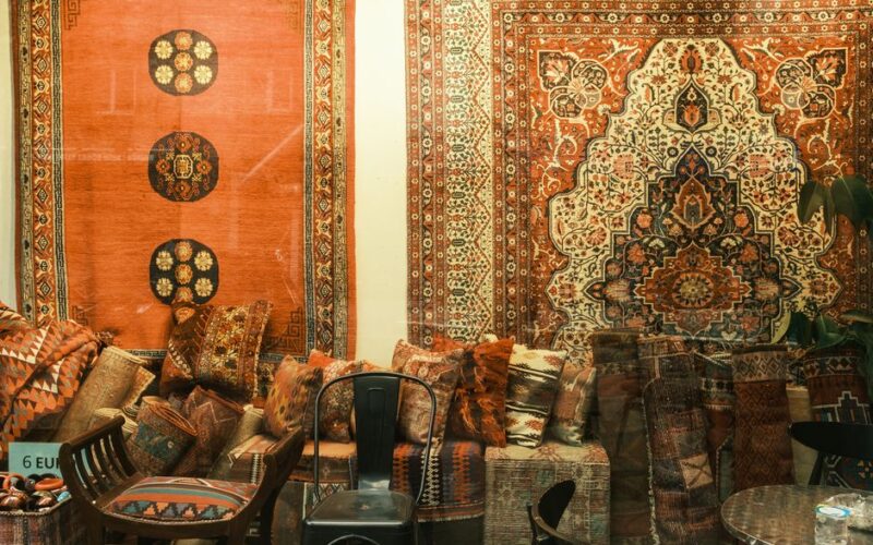 A vibrant display of traditional Persian rugs and patterned cushions in a cozy setting, perfect for decor inspiration.