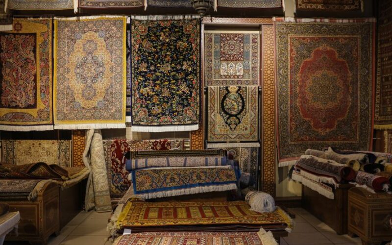 A captivating display of intricately designed traditional rugs in a cozy shop.