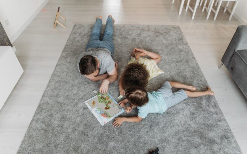 Father and kids bonding over a puzzle on a cozy living room carpet.