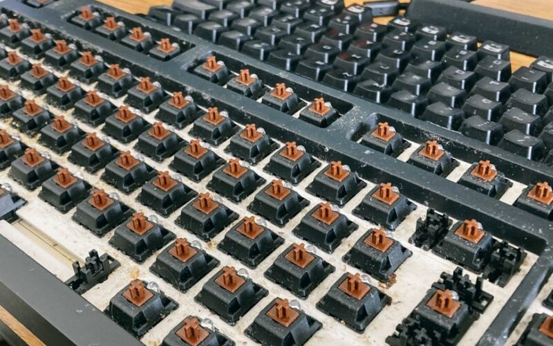From above of computer keyboard with removed keycaps for cleaning dust and dirt